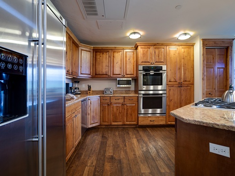 Your fully equipped kitchen awaits with rich wood cabinetry, stainless steel appliances, and granite countertops—perfect for preparing meals during your stay.