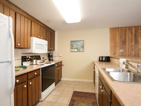Your fully equipped kitchen provides everything you need to prepare meals during your stay, with warm wood cabinetry, modern appliances, ample counter space, and a homey mountain-inspired ambiance that makes cooking feel effortless.