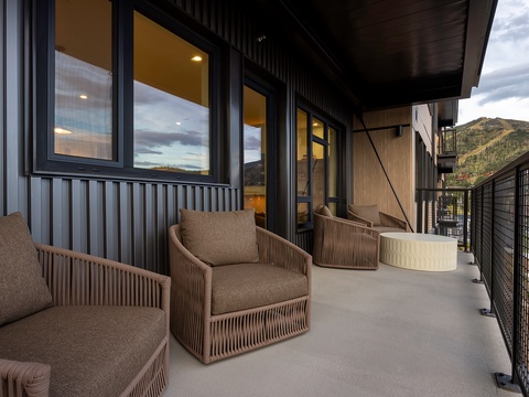 Settle into your private balcony with mountain vistas rising in the distance, where comfortable lounge chairs and modern design create the perfect spot to unwind and soak in the natural beauty surrounding you.
