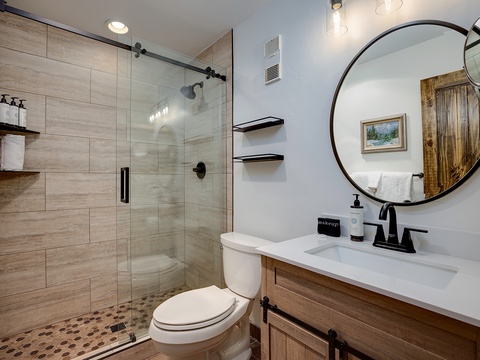 Freshen up in your beautifully designed bathroom with a spacious walk-in shower, modern fixtures, and rustic wood accents that create a warm, inviting retreat.
