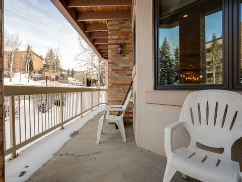 A covered balcony nestled in a quiet residential neighborhood, perfect for enjoying crisp mountain air and serene winter views from your private retreat.