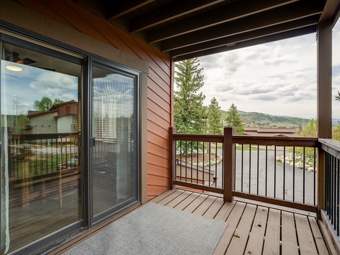 This covered balcony frames stunning mountain and valley views, offering your perfect spot to sip morning coffee or unwind as clouds drift across the forested hillside.