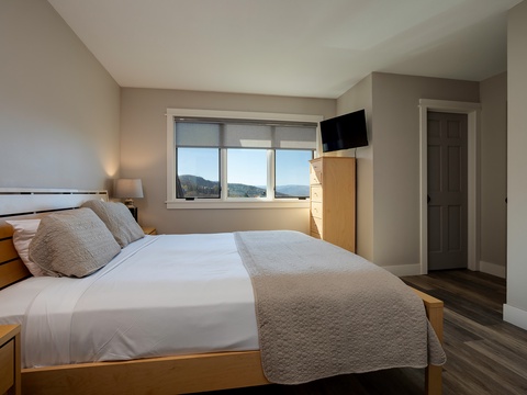 Wake to mountain views framed by your bedroom window, where crisp linens and warm wood tones create a peaceful retreat for restful nights.