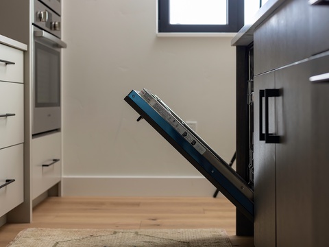 Natural light floods your modern kitchen, where stainless steel appliances and custom cabinetry create a sleek, functional space for preparing meals during your stay.