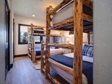 This cozy bunk room features rustic log-frame beds with plush bedding, perfect for families or groups. Your kids will love the mountain lodge charm and comfortable sleeping spaces.