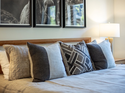 Sink into a plush bed piled high with soft pillows in every shade of gray and blue. Your perfect night's sleep awaits in this thoughtfully styled bedroom.