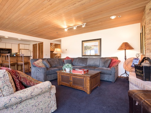 Unwind on plush seating in your spacious living room, where warm wood accents and a cozy fireplace create a welcoming retreat after exploring the area.