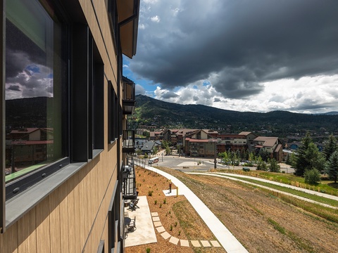 A mountain resort community nestled beneath dramatic skies, with nearby trails and scenic alpine surroundings.
