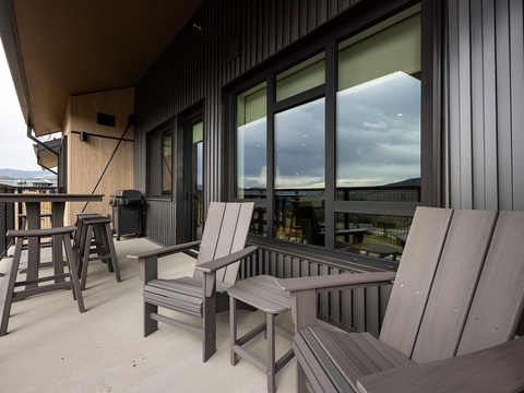 Step out onto your private balcony, where comfortable Adirondack chairs and a dining set invite you to relax with mountain and neighborhood views stretching before you—perfect for morning coffee or evening grilling.