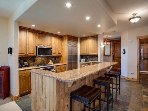 Gather around your spacious granite island for meals or conversation, with gleaming stainless appliances and warm wood cabinetry creating a welcoming mountain retreat atmosphere.