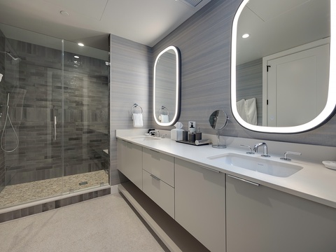 Slip into a sleek, modern retreat featuring a spacious walk-in shower and bright LED mirrors to start your mornings refreshed.