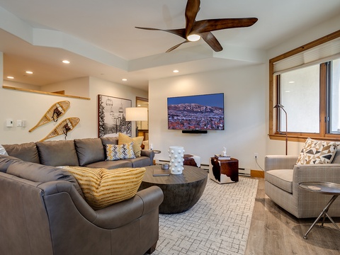 Sink into plush seating in your spacious living room, complete with a ceiling fan and mountain-view TV. Stylish decor and abundant natural light create the perfect retreat after your adventures.