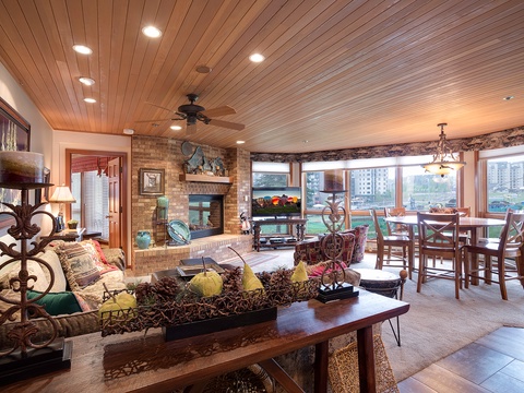 Unwind in this spacious, light-filled living area where warm wood ceilings and a cozy fireplace create the perfect retreat after your day of adventure.