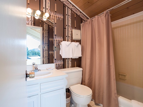 Step into your private bathroom with fresh linens, warm lighting, and all the essentials for a comfortable stay, including a full tub-shower combo and stylish tile accents.