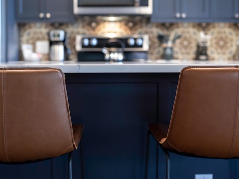 Enjoy casual mornings at your fully equipped kitchen island, featuring modern appliances and elegant cabinetry with stylish seating for easy dining.