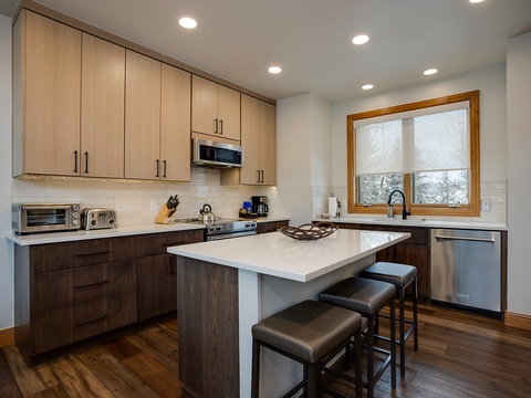 Your fully equipped kitchen invites home-cooked meals with modern appliances, generous counter space, and cozy island seating where you can gather over morning coffee or evening wine.
