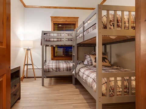 Your cozy bunk room sleeps the whole crew, with plaid linens and warm wood details creating that cabin-in-the-mountains vibe everyone will love.