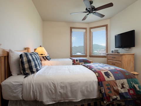Sink into soft linens and let the ceiling fan's gentle breeze lull you to sleep. Wake to natural light streaming through your windows, perfectly framed by warm wood tones throughout your cozy retreat.