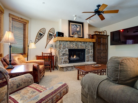 Cozy up in your mountain retreat with a stone fireplace, plush seating, and rustic charm perfect for après-ski relaxation.