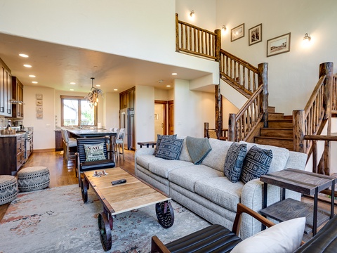 Relax in your spacious open-concept living area featuring rustic wood accents, plush seating, and a fully equipped kitchen perfect for gathering with loved ones after a day exploring.
