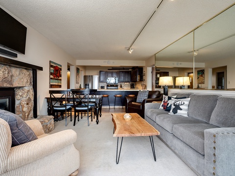 Settle into this inviting open-concept space where your living, dining, and kitchen flow together. Unwind by the stone fireplace, share meals at the dining table, and enjoy the warm ambiance of home.