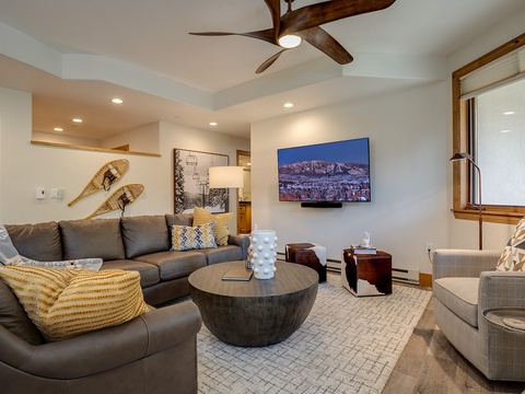 Sink into plush seating in your inviting living room, where mountain views on the wall-mounted TV and cozy textures create your perfect après-ski retreat.