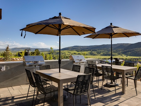 An expansive patio with built-in grills and mountain valley views creates an ideal setting for your outdoor gatherings and al fresco dining under the sun.
