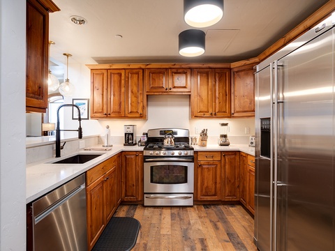 Your fully equipped kitchen features warm wood cabinetry, modern stainless appliances, and all the essentials for preparing delicious home-cooked meals during your stay.