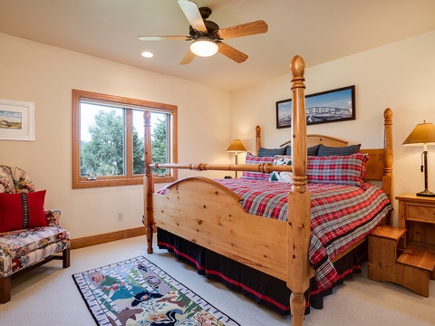 Settle into your cozy retreat with a handcrafted wood bed dressed in cheerful plaid, bedside lamps casting a warm glow, and treetop views framing your peaceful mornings and restful evenings.