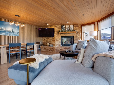 Sink into plush seating by the glowing fireplace while you watch your favorite shows or take in stunning mountain views through the expansive windows—your cozy alpine retreat awaits.