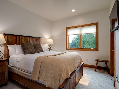 Drift off beneath crisp linens and a cozy throw, while soft lamplight and treetop views from your window wrap you in peaceful mountain comfort.