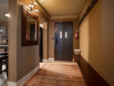 Step into your welcoming entryway with warm lighting and thoughtful touches. A framed mirror and convenient bench with storage basket help you settle in and feel at home from the moment you arrive.