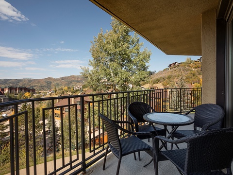 Your private balcony overlooks rolling hills and autumn foliage, with comfortable seating for morning coffee or evening relaxation under the open sky.