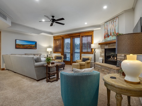 Unwind in your spacious living room with plush seating, a cozy fireplace, and mountain views from the balcony—perfect for relaxing evenings after your adventures.