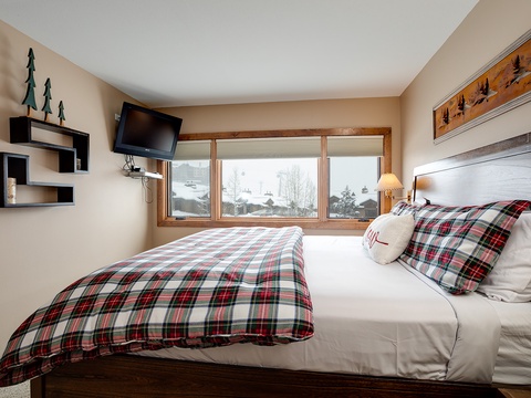 Your mountain retreat awaits with crisp linens, cozy plaid bedding, and serene winter views. Wake up refreshed to snowy peaks and pine trees just outside your window.