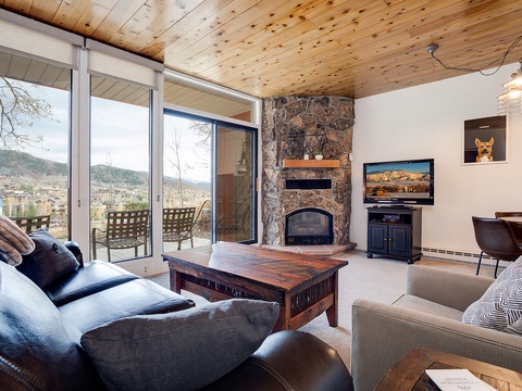 Sink into plush seating and gaze at mountain vistas through floor-to-ceiling windows. The stone fireplace adds warmth while you unwind after a day exploring nearby slopes.