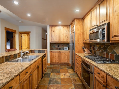You'll love preparing meals in this spacious, fully equipped kitchen with warm wood cabinetry, granite countertops, stainless steel appliances, and a gas range for your culinary adventures.