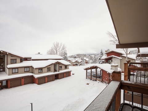 A winter wonderland view from the property, with snow-blanketed neighboring chalets and alpine scenery creating a cozy mountain retreat atmosphere.