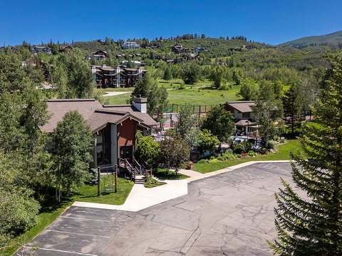 Nestled in a mountain community, the property offers ample parking, lush green surroundings, and easy access to nearby amenities and recreational areas.