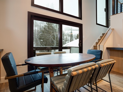 Gather around this elegant dining table with snowy mountain views streaming through floor-to-ceiling windows, where meals become memorable moments in your alpine retreat.