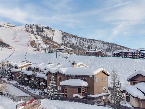 Winter wonderland nestled at the base of pristine ski slopes, surrounded by snow-dusted evergreens and modern mountain lodges—a picturesque alpine retreat.