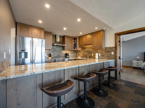 Gather around this spacious kitchen island with granite countertops, modern appliances, and rustic wood accents—your home base for cooking and conversation during your stay.