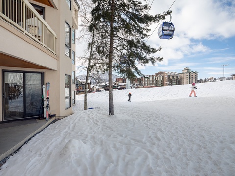 Modern ski-in property with direct slope access, gondola lift overhead, and alpine resort amenities within view—ideal for winter sports enthusiasts.
