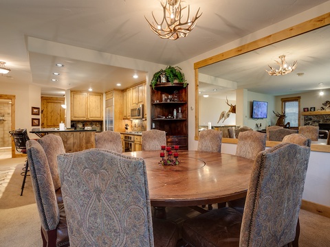 Gather around the grand dining table with your group, where rustic elegance meets mountain charm—perfect for shared meals and lasting memories.