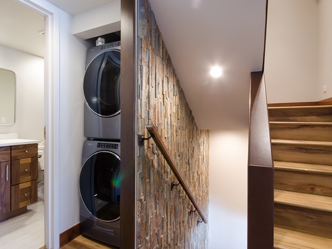 Your in-unit washer and dryer make packing light easy, tucked neatly into a stylish alcove with warm wood accents and natural stone details.