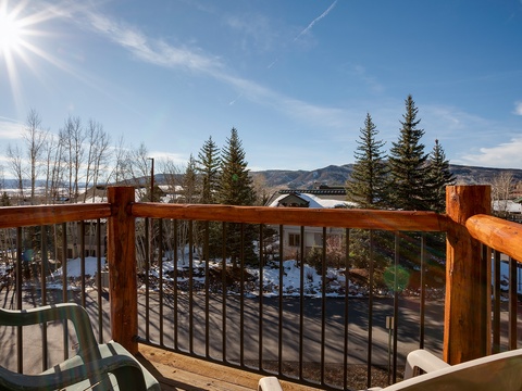A sun-soaked balcony showcasing sweeping mountain vistas, evergreen forests, and crisp winter air. Your private outdoor retreat for morning coffee or sunset relaxation, framed by rustic wood railings and expansive blue skies.