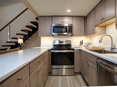 You'll love preparing meals in this modern, fully equipped kitchen with sleek cabinetry, stainless steel appliances, and ample counter space for easy cooking and entertaining.