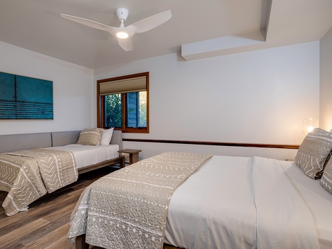 Unwind in your serene twin-bed retreat, where crisp linens, soothing coastal artwork, and a gentle ceiling fan create the perfect haven for restful nights.