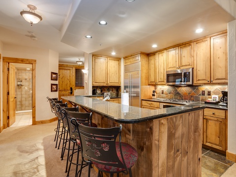 Your fully-equipped kitchen awaits, complete with warm wood cabinetry, granite counters, and a spacious island for gathering—perfect for preparing mountain meals and making memories together.