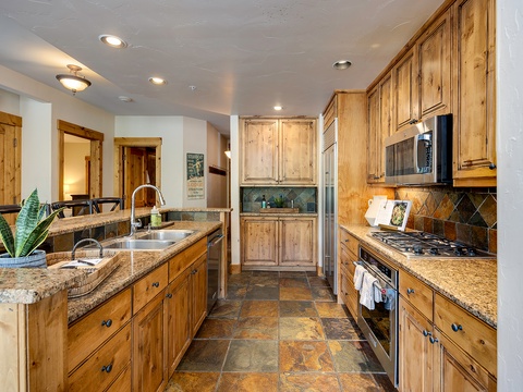 Prepare delicious meals in your fully equipped kitchen, complete with granite counters, warm wood cabinetry, and modern appliances. The spacious layout and thoughtful design make cooking a pleasure during your mountain getaway.